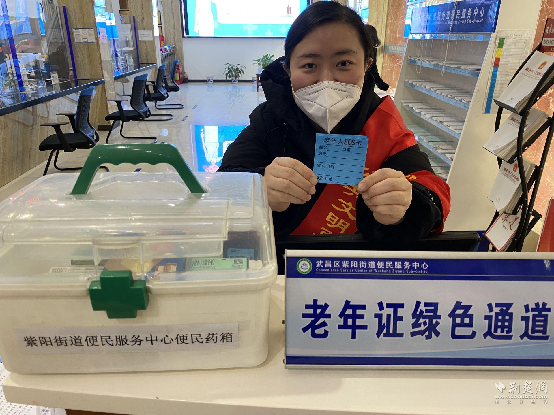 工作人员舒艳拿着老年人“SOS”卡.JPG.JPG