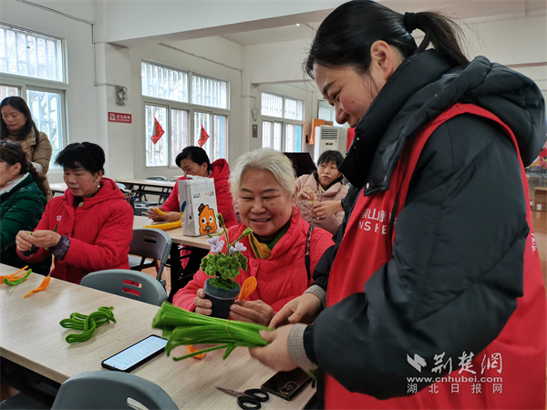 志愿者帮助居民制作扭扭花.jpg