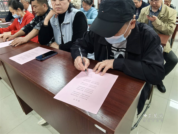社区志愿者在倡议书上签字.jpg