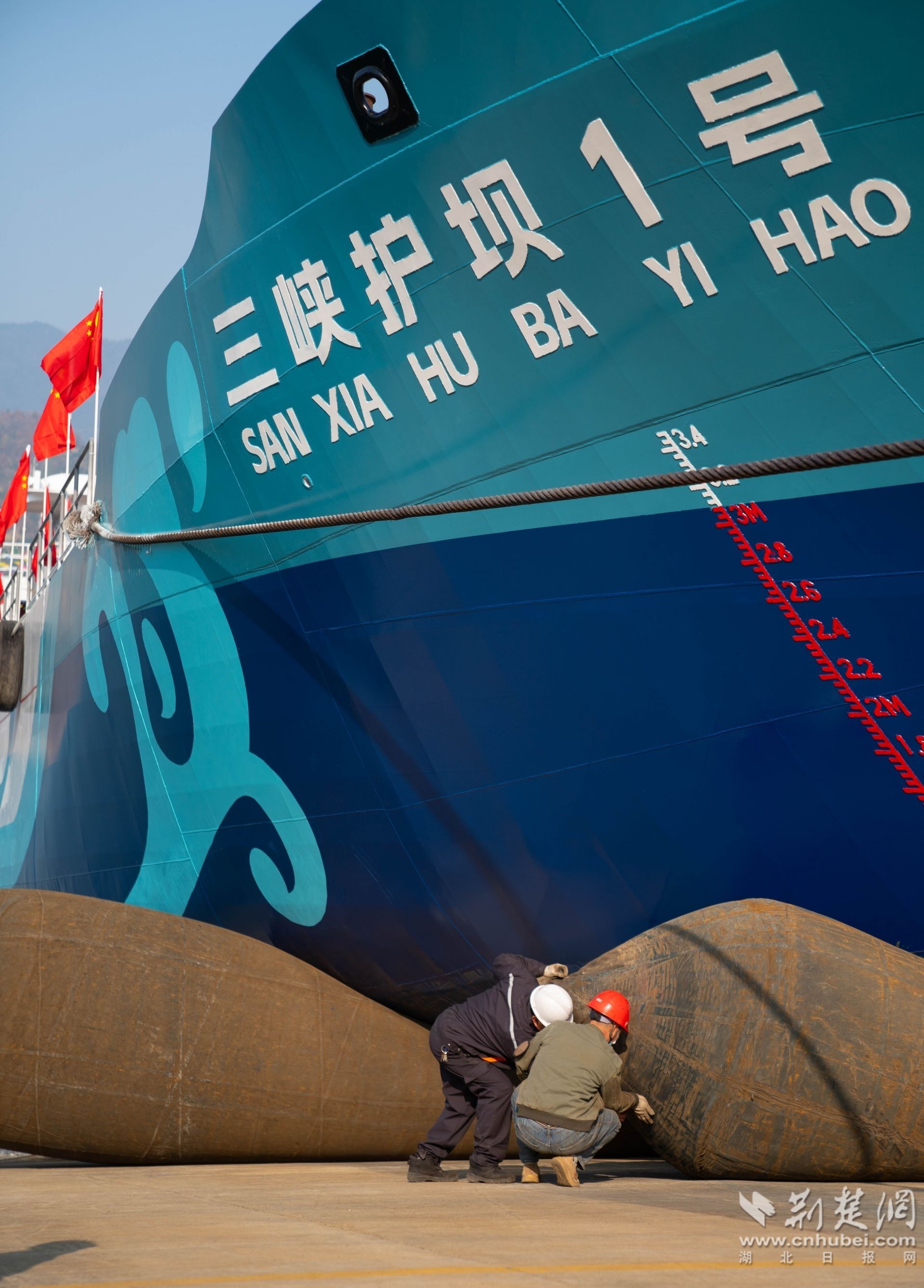 秭归华星船务有限公司工作人员正为纯电动清漂船三峡护坝1号下水使用的气垫充气 周仕伟 摄 (3).jpg.jpg