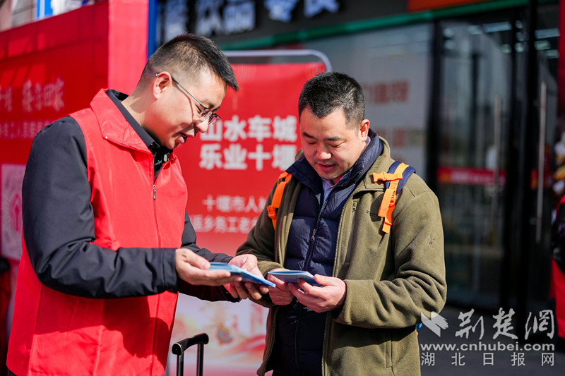 高铁十堰东站出站口，志愿者发放宣传资料.jpg