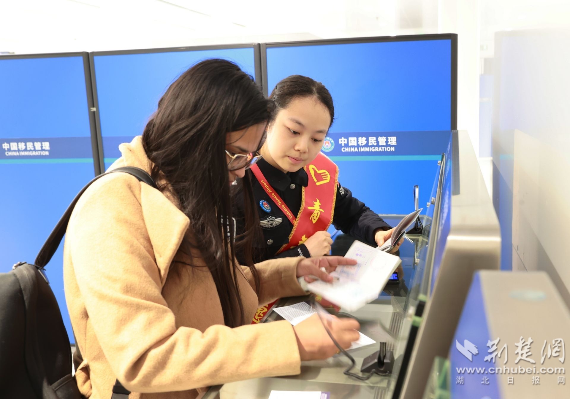 图为民警协助旅客办理手续 （钟鹏宇摄）.JPG.JPG