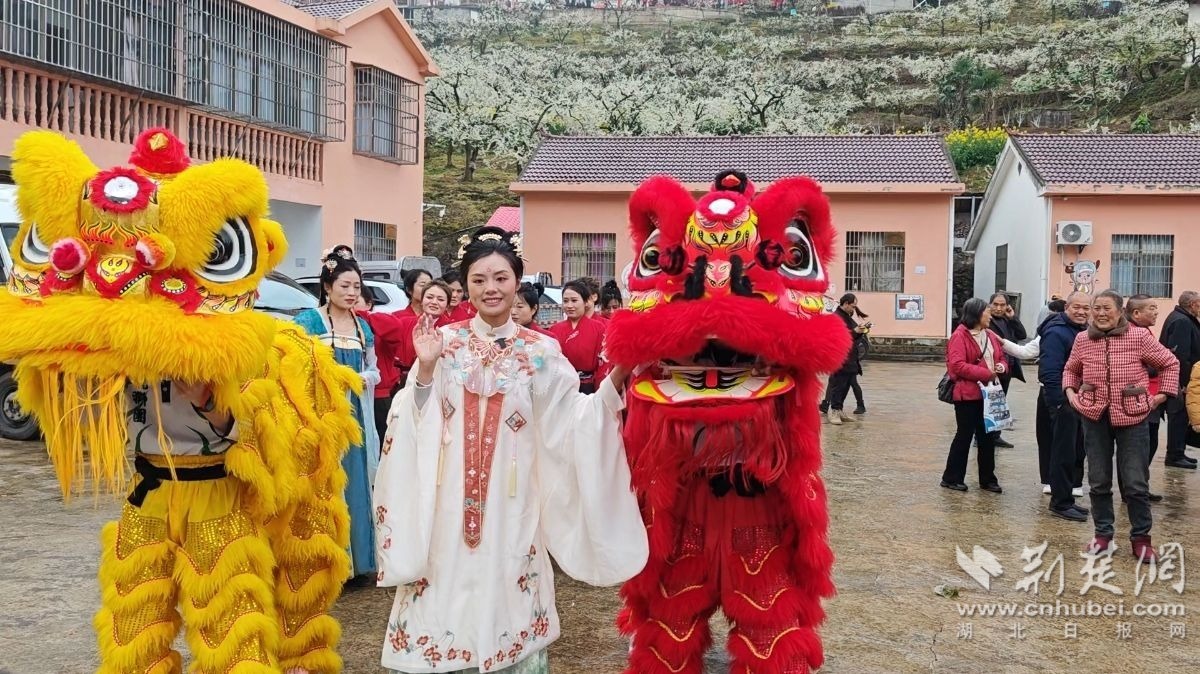 2026年3月20日,湖北省宜昌市沙镇溪镇高潮村,返乡青年向艳青与舞狮工作人员互动.jpg.jpg