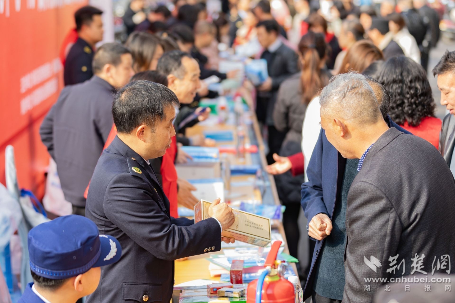 2026年3月13日，湖北省秭归县开展“3·15”国际消费者权益日纪念咨询活动，现场工作人员正在指导市民如何辨别香烟真伪。彭强摄